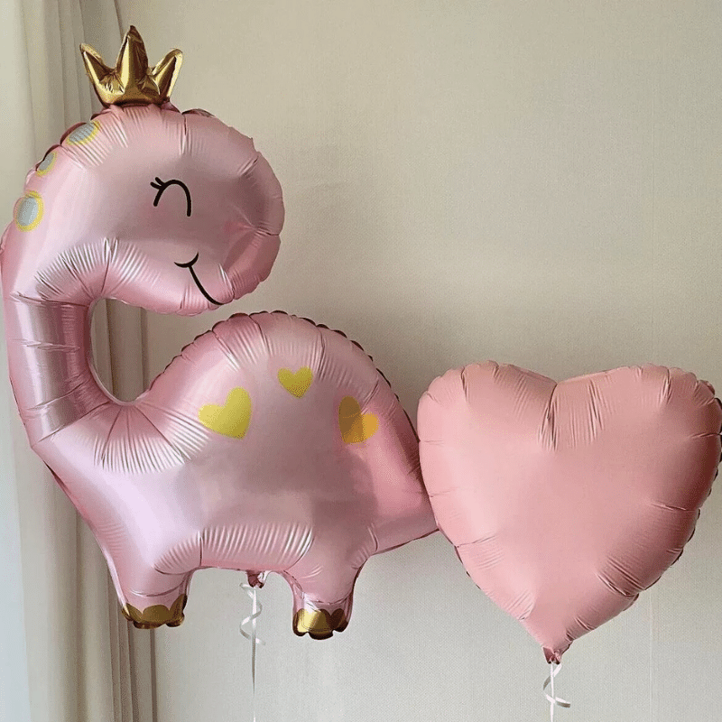 Pink-themed party supplies. Crown-topped pink dino party balloon
